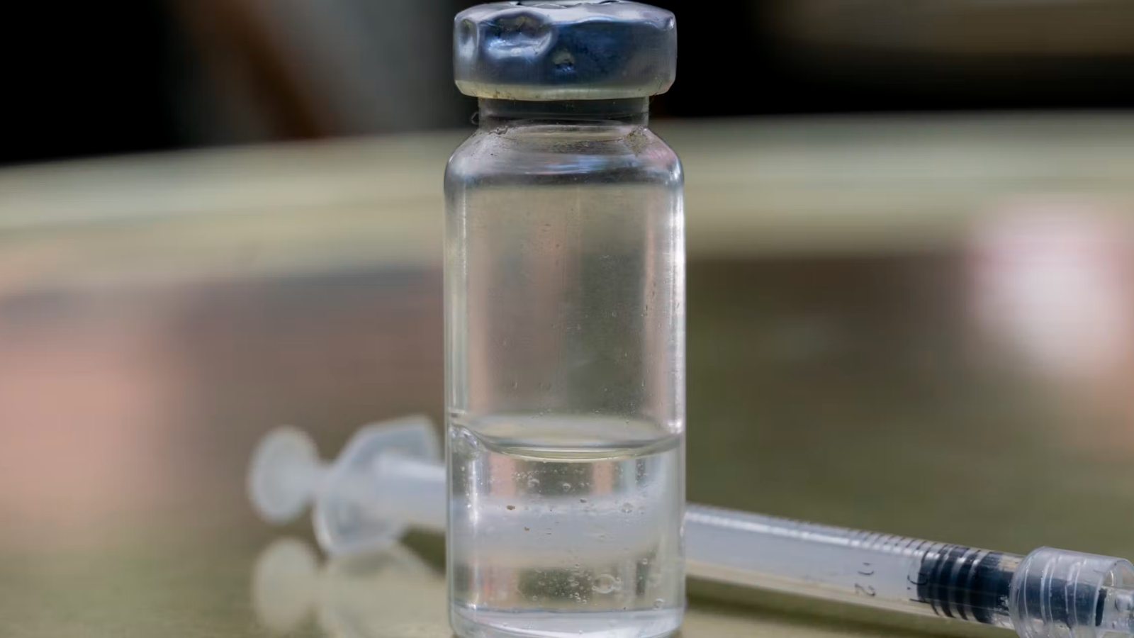 A peptide vial and syringe on a table